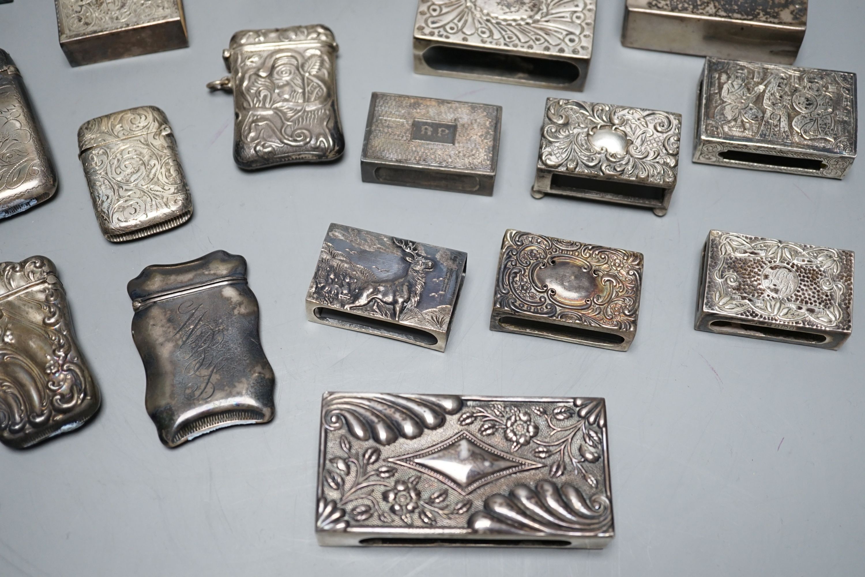 A small collection of nine mainly early 20th century silver or sterling vesta cases, largest 60mm and fourteen assorted similar silver or white metal match sleeves